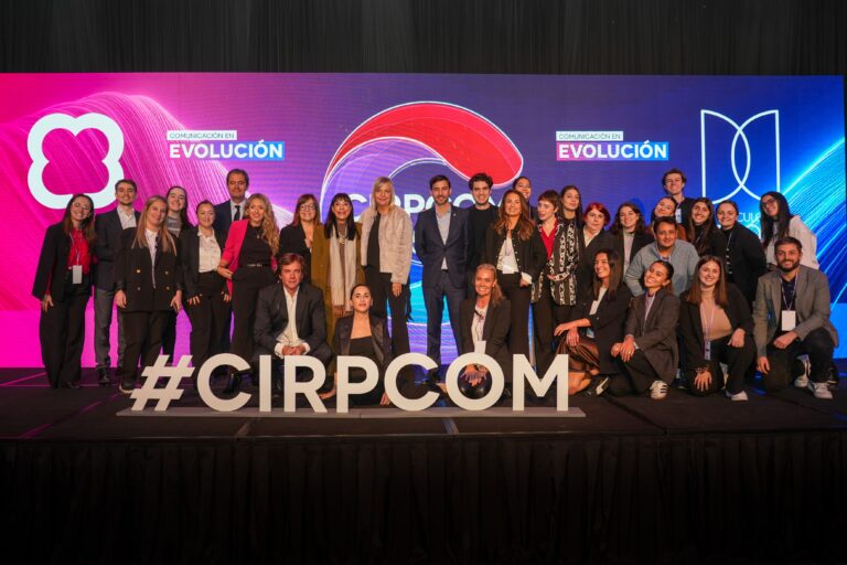 Foto grupal del equipo organizador y participantes de CIRPCOM 2025 sobre el escenario del evento en Argentina, con pantalla de fondo y cartel con el hashtag #CIRPCOM