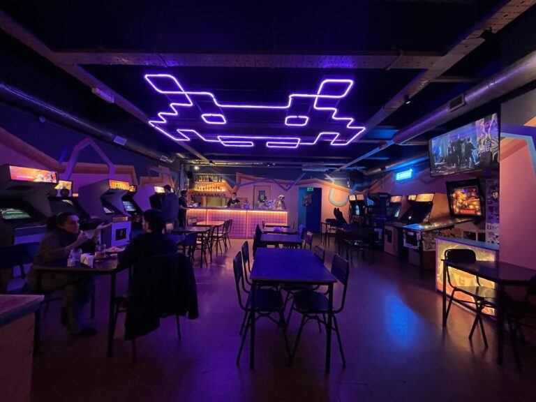 Fachada del bar El Destello, recientemente adquirido por Grupo MIZ Juegos, con su cartel tradicional iluminado por la noche