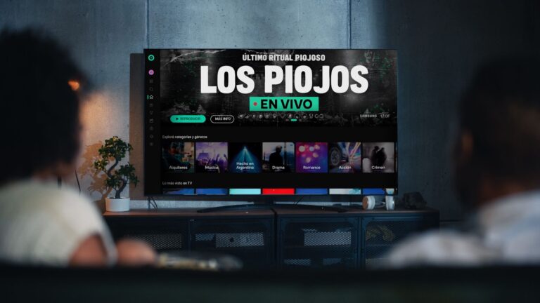 Pantalla de TV con la transmisión en vivo del último recital de Los Piojos por Flow, vista desde el living con dos personas observando el show