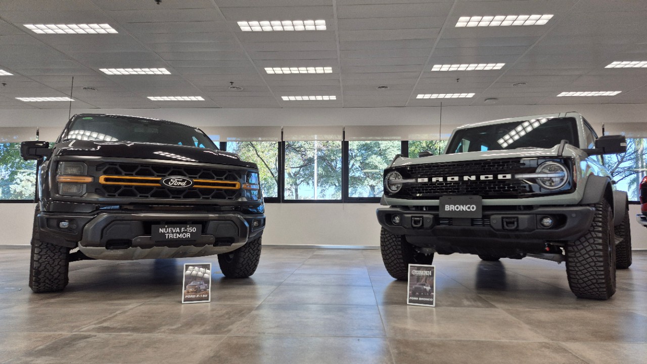 Vista frontal de las camionetas Ford F-150 Tremor y Ford Bronco exhibidas en un showroom, reconocidas por los Premios Autocosmos como los mejores vehículos del año en sus categorías