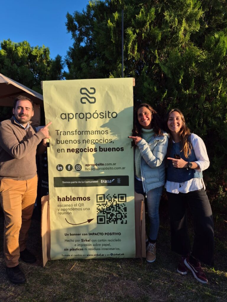 Personas colaborando frente a una pizarra con íconos de sostenibilidad, impacto social y económico, representando los nuevos servicios de Apropósito, la unidad de Trasa orientada al Triple Impacto