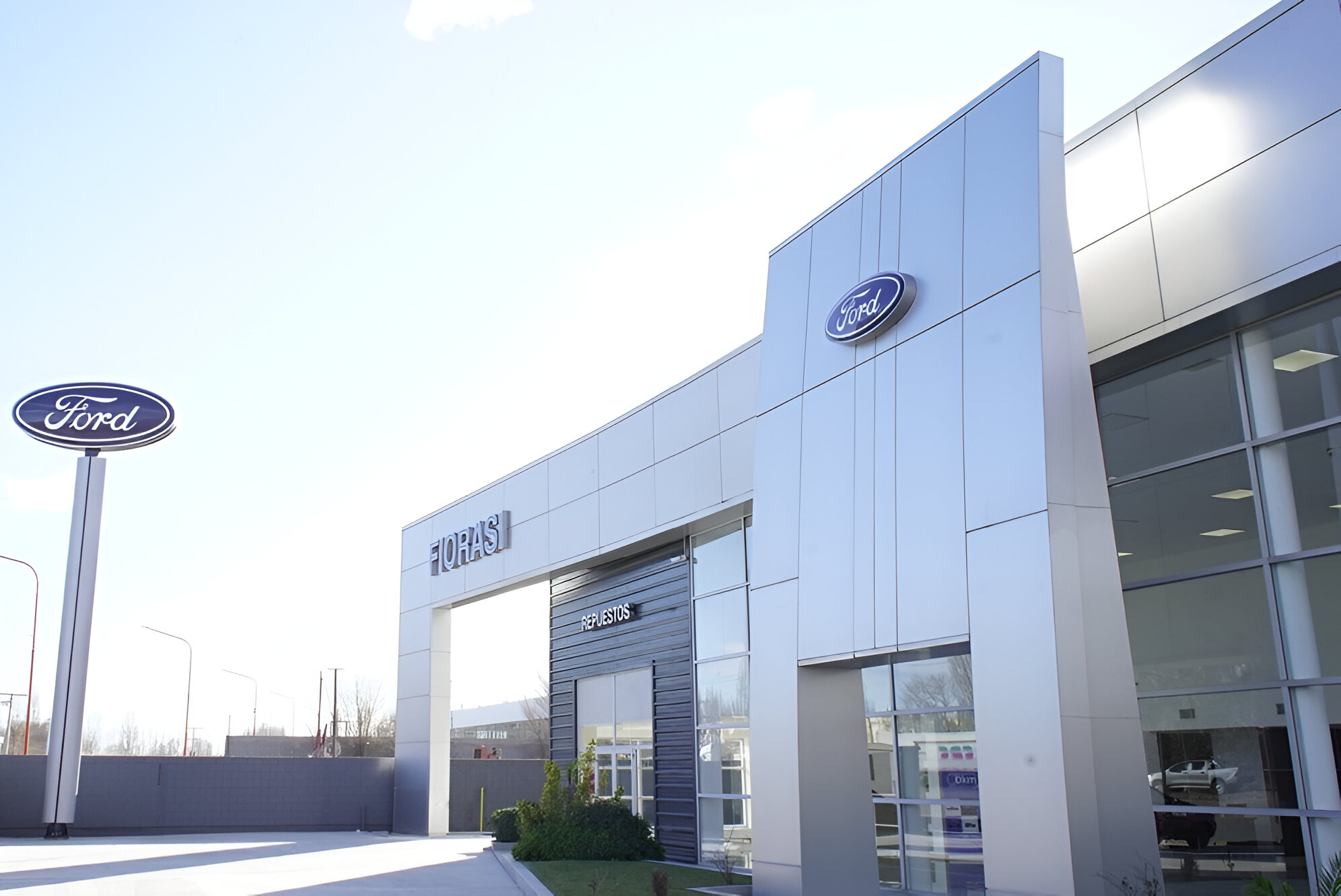Fachada moderna de la nueva concesionaria Fiorasi con cartelería de Ford, ubicada en la región de Neuquén y Río Negro