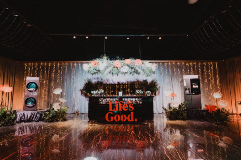 Bar decorado con flores y luces en el evento del 25° aniversario de LG en Argentina, junto a exhibiciones de electrodomésticos de la marca