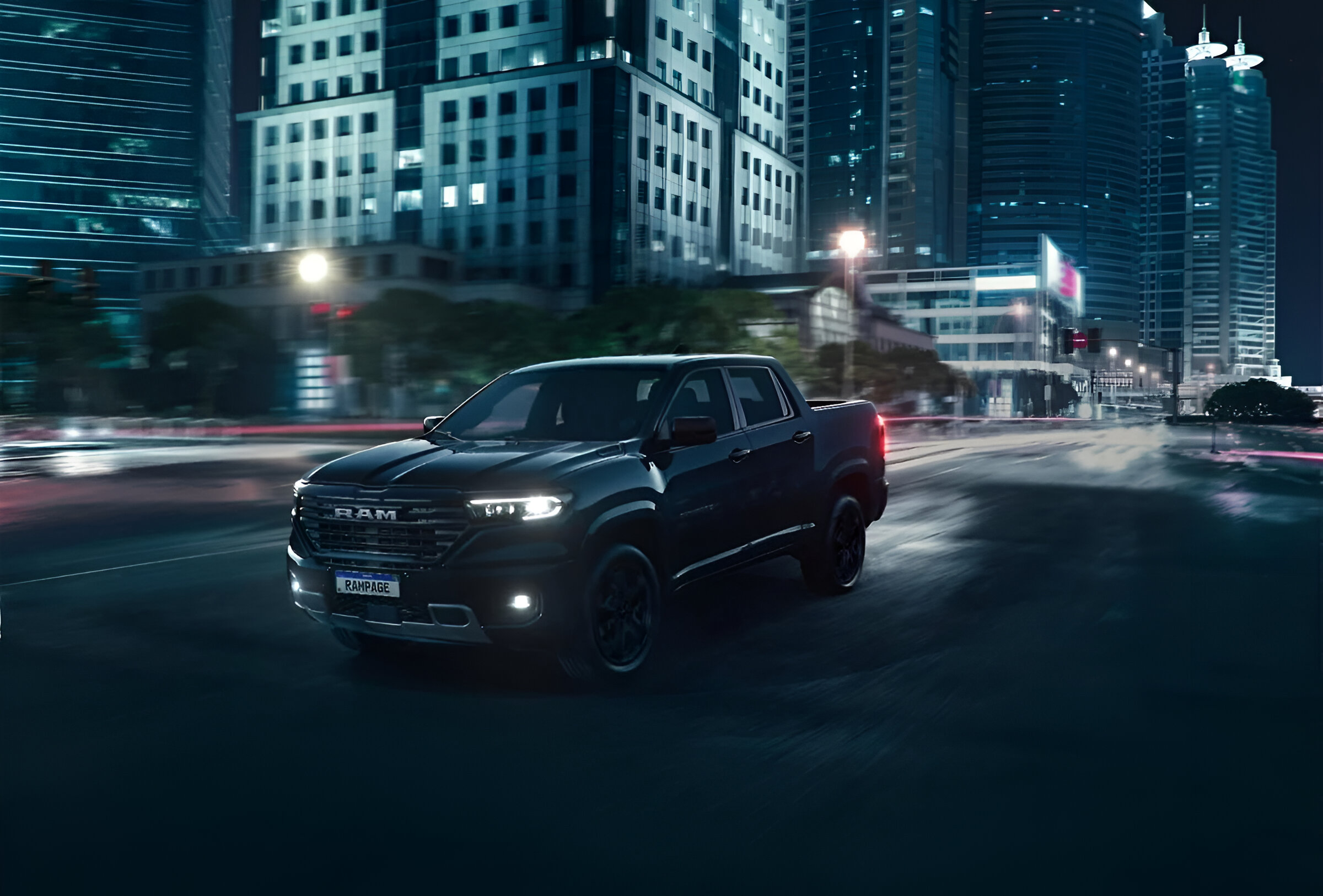 Pick-up RAM Rampage negra circulando de noche por una avenida urbana, rodeada de edificios modernos iluminados