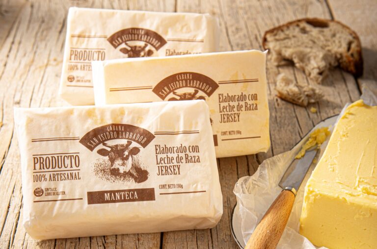 Paquetes de manteca artesanal Munchi’s elaborada con leche Jersey junto a una porción servida en plato