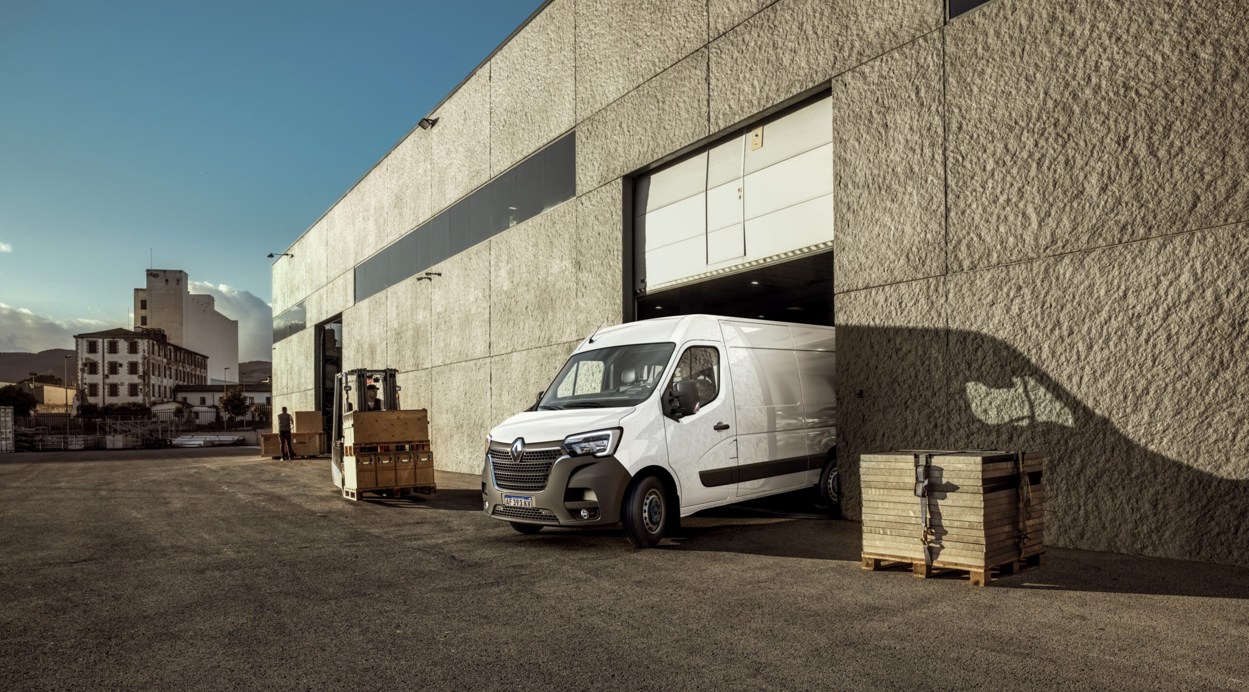 Utilitario Renault Master 2025 blanco saliendo de un depósito de carga en zona industrial