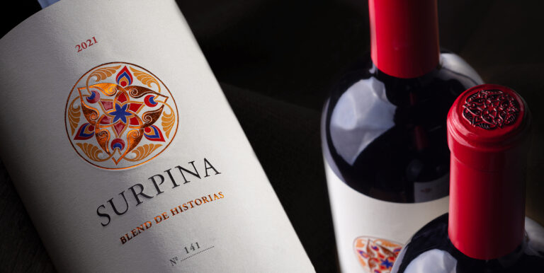 Primer plano de una botella de vino Surpina 2021 de Bodega Del Fin Del Mundo, con diseño colorido y elegante, representando un homenaje al legado familiar