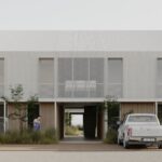 Fachada moderna de viviendas con camionetas estacionadas, parte del desarrollo inmobiliario Nativa Housing en Añelo