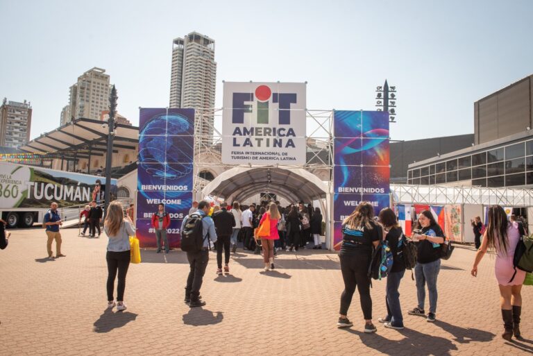 Entrada principal de la Feria Internacional de Turismo FIT en Buenos Aires con visitantes y carteles de bienvenida