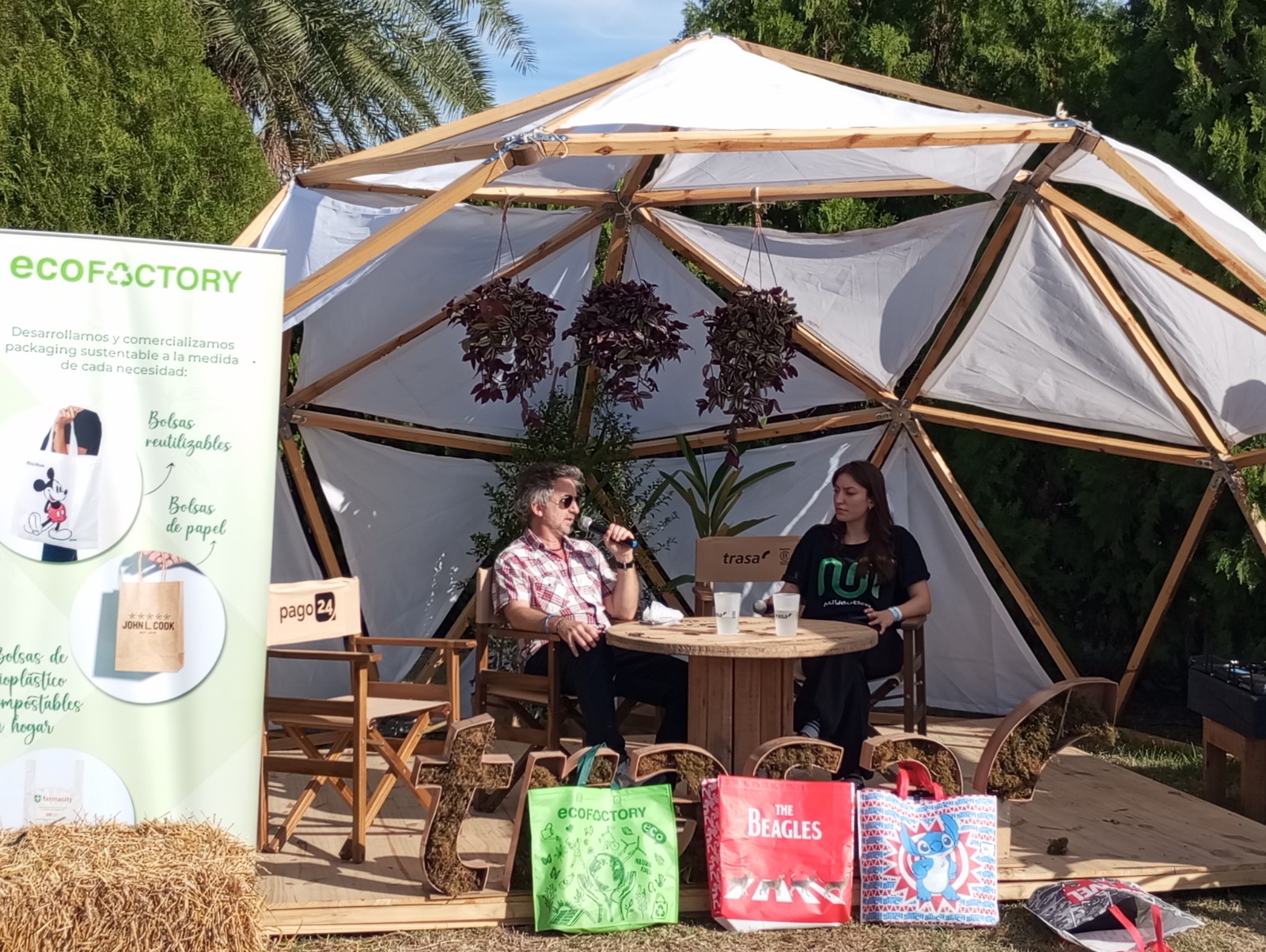 Entrevista en un espacio sustentable con emprendedores y bolsas reutilizables en exhibición, representando el impacto positivo de las empresas