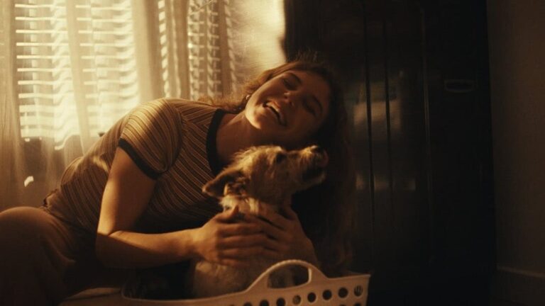 Joven sonriente abrazando a su perro en un ambiente hogareño iluminado por luz cálida, reflejando historias cotidianas