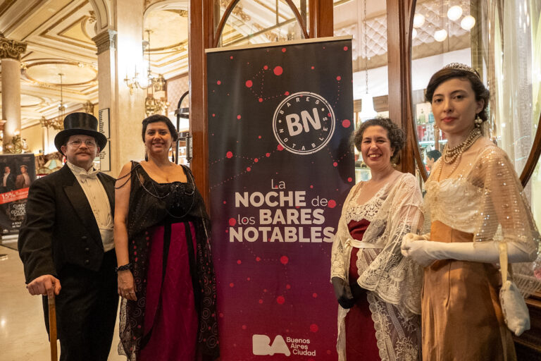 Personas caracterizadas con vestimenta de época celebran La Noche de los Bares Notables en un café histórico de Buenos Aires