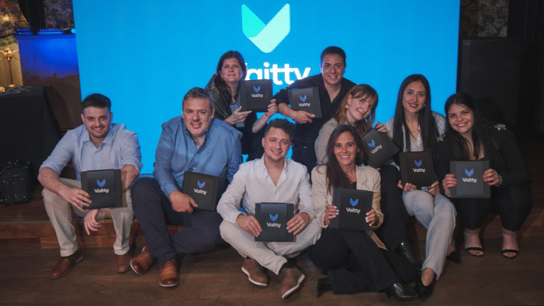 Integrantes de Vaitty posando en un evento con el logo de la startup insurtech de fondo