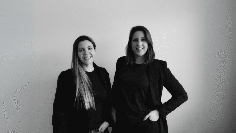 Dos diseñadoras argentinas posando juntas en retrato profesional blanco y negro