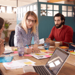 Grupo de profesionales jóvenes reunidos en una oficina compartiendo ideas y estrategias de negocio