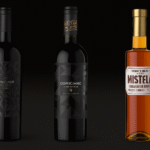 Tres botellas de vino Domiciano sobre fondo oscuro: Gran Reserva Malbec, Corte Estrella 9 y Mistela.