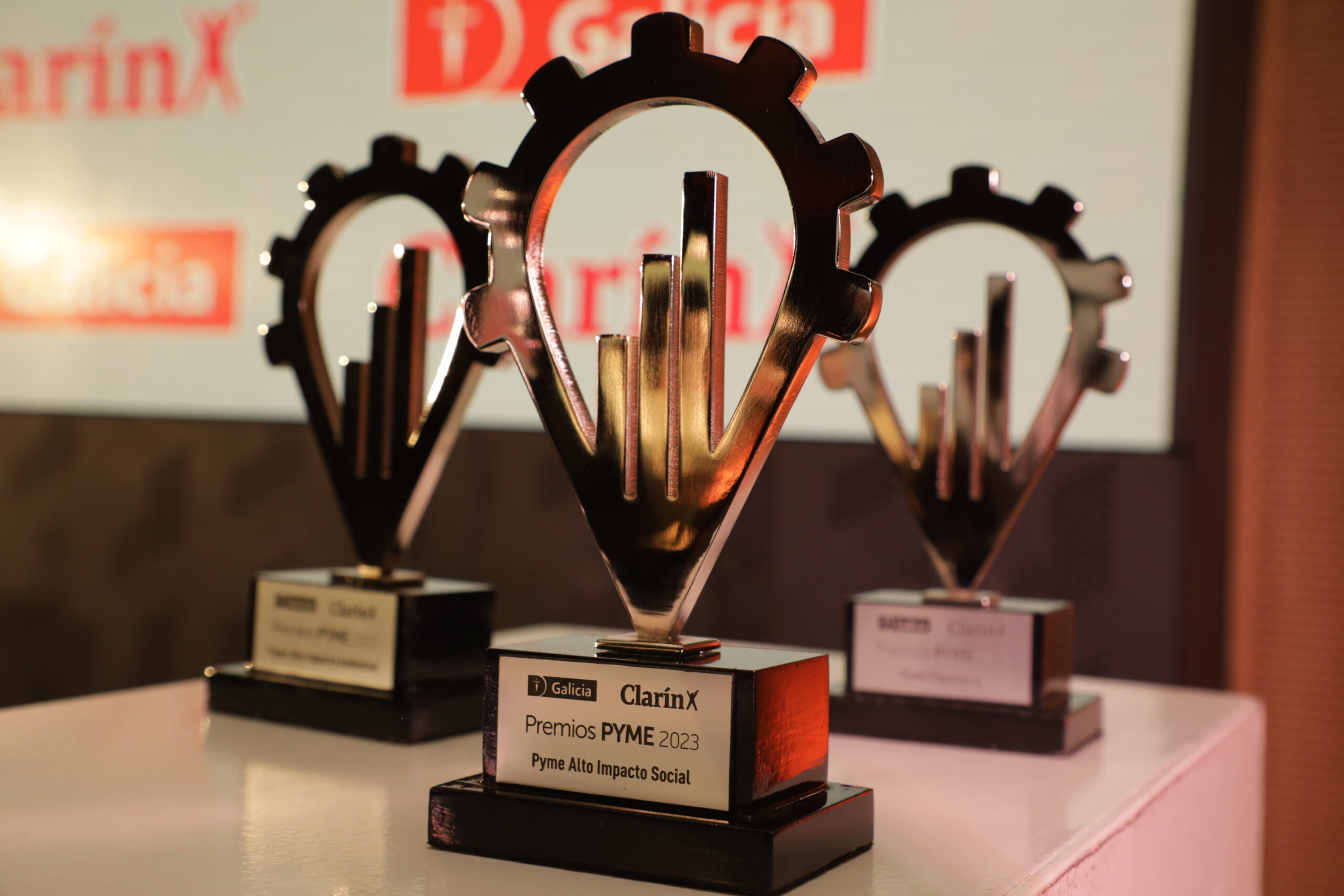 Primer plano de las estatuillas de los Premios PYME que entregan Galicia y Clarín, exhibidas sobre una mesa antes de la ceremonia