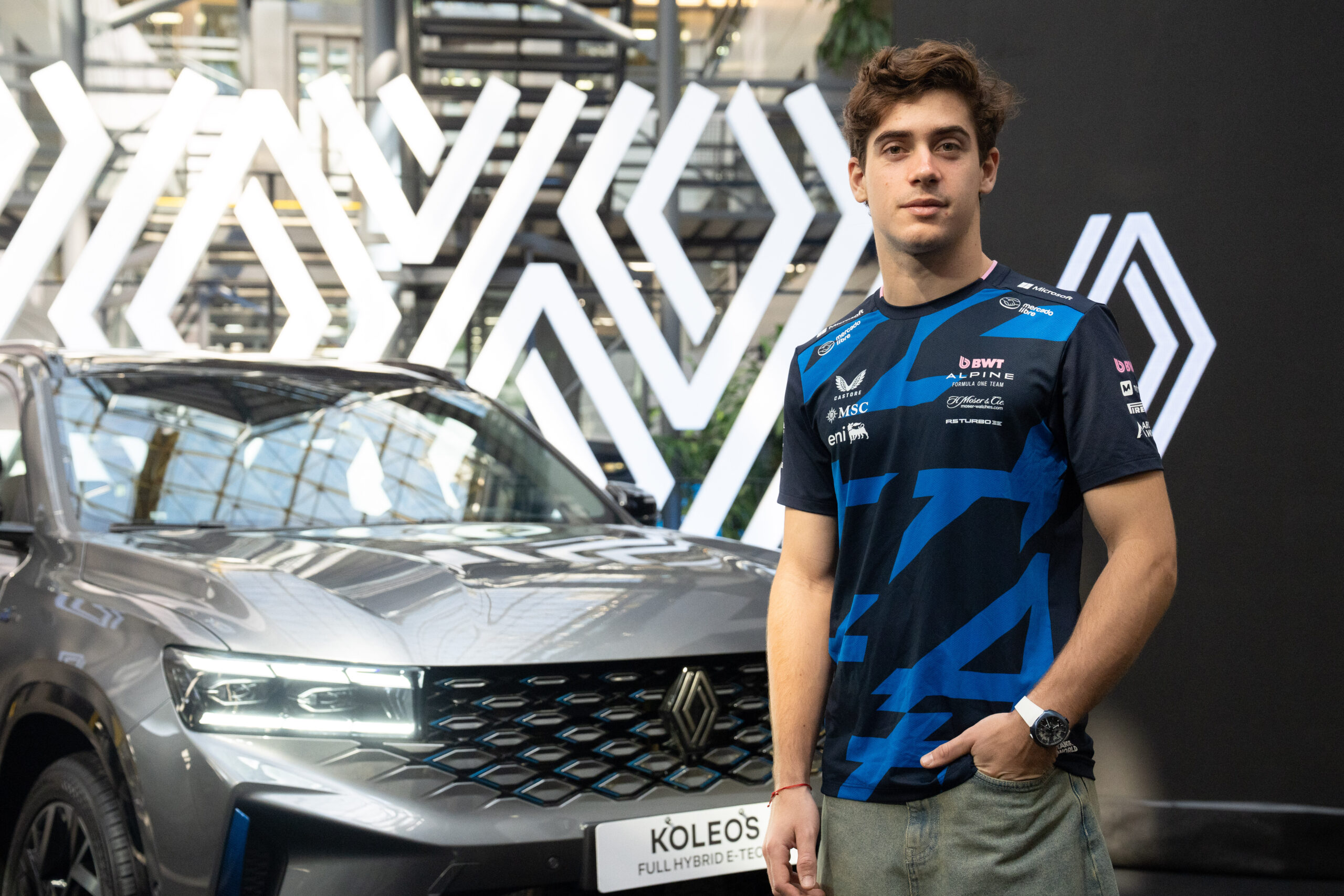 Franco Colapinto posa en las oficinas de Renault Argentina junto a un Renault Koleos híbrido durante su visita de fin de año