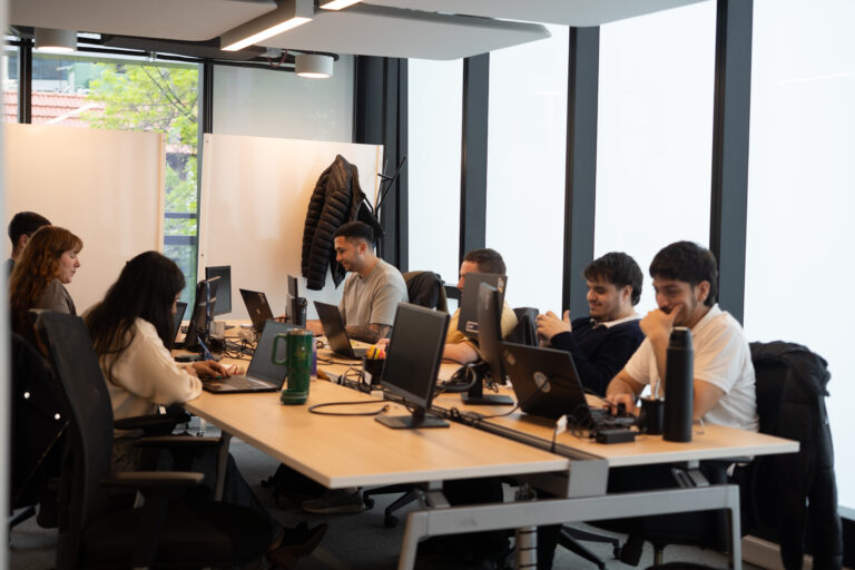 Equipo de trabajo colaborando en una oficina moderna, representando la posibilidad de elegir entre trabajo presencial, remoto o híbrido según las preferencias de cada persona