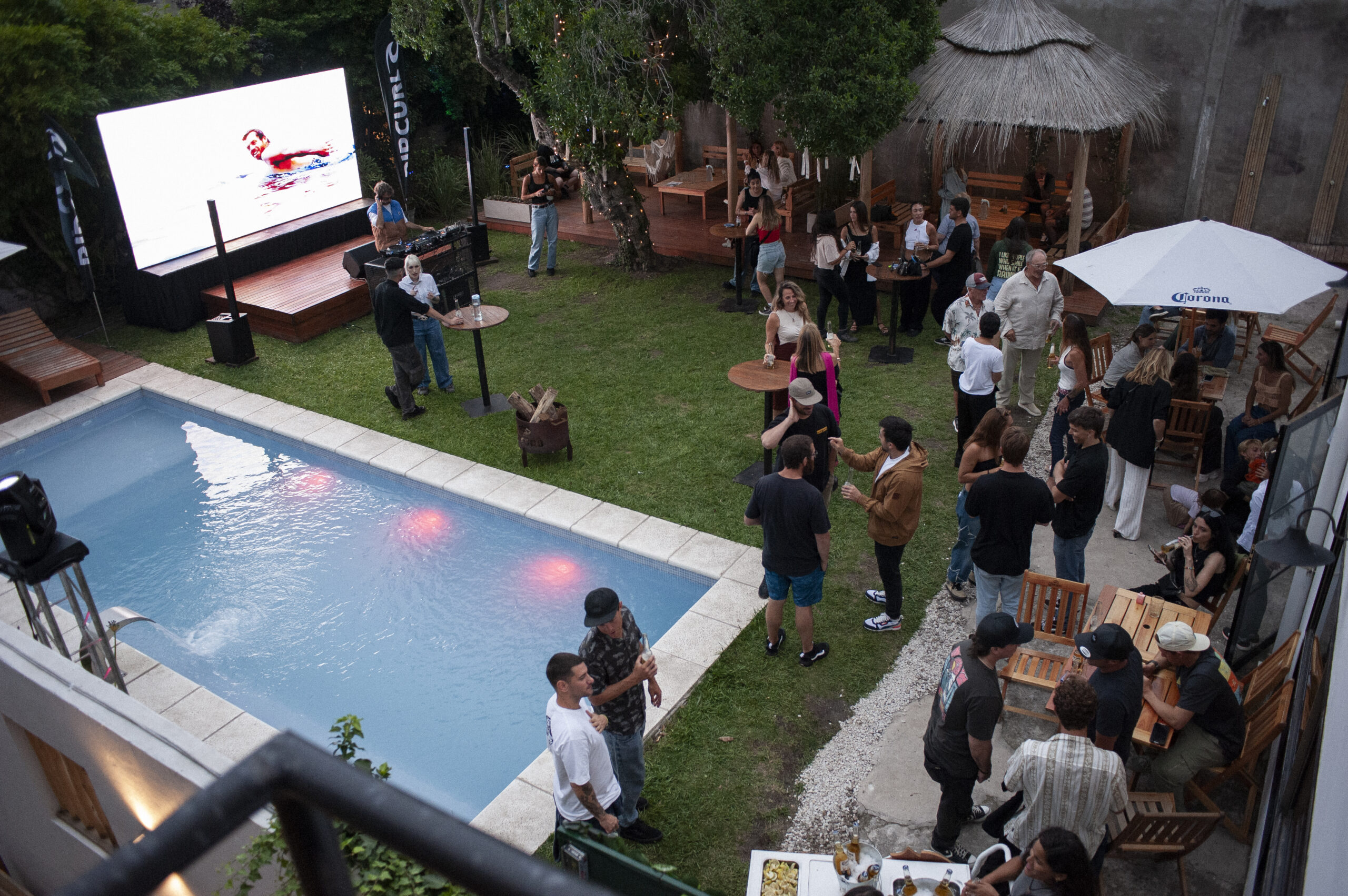 Vista aérea del evento en Las Golondrinas con pileta, música y grupos de personas disfrutando al aire libre en Mar del Plata durante las celebraciones de Año Nuevo