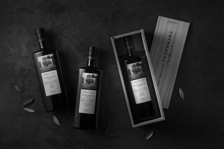 Botellas de aceite de oliva extra virgen Temporada dispuestas sobre una superficie oscura, una de ellas dentro de una caja de madera, en una estética sofisticada y minimalista