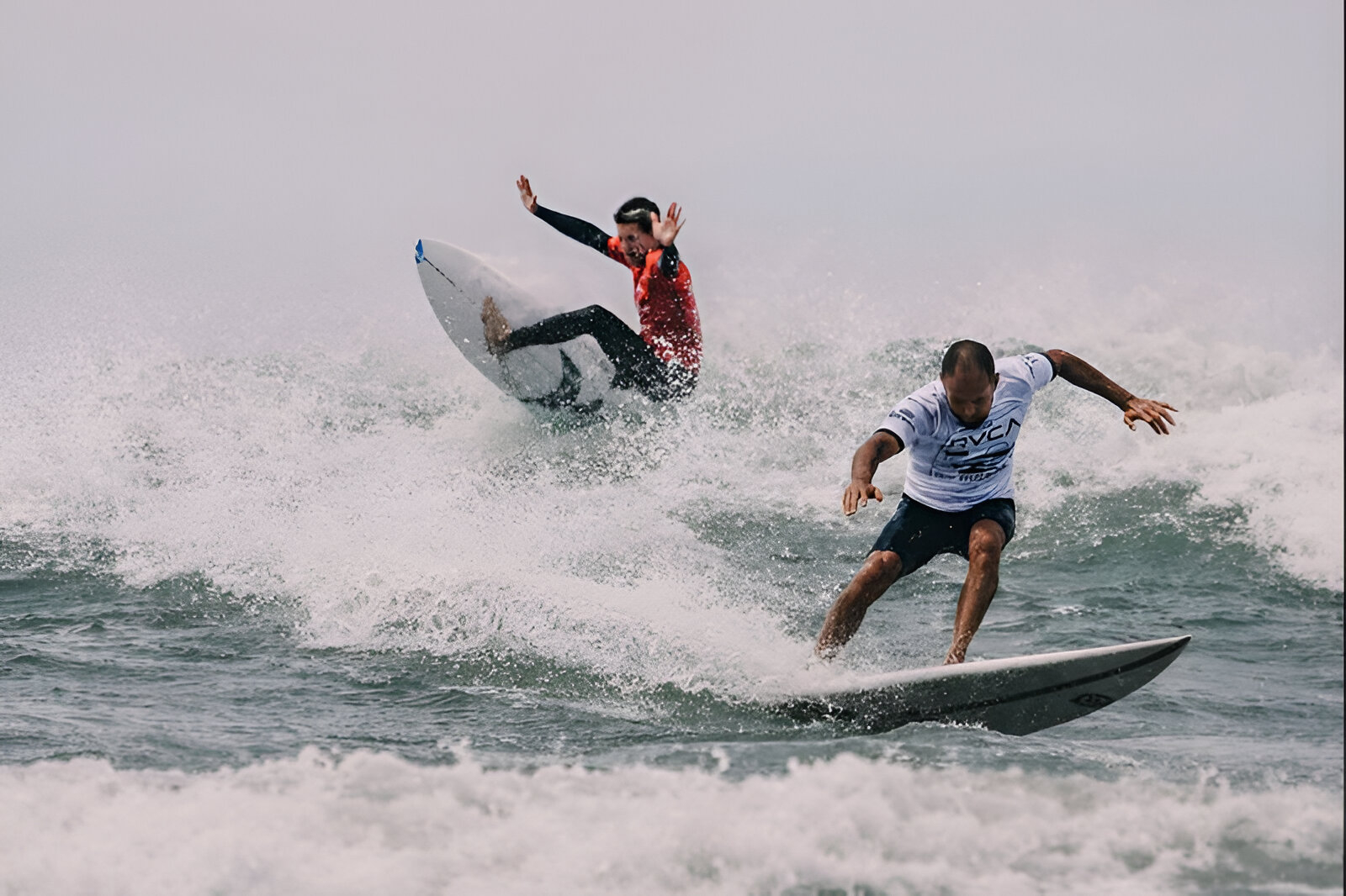 Surfistas compitiendo en el mar de Chapadmalal durante una jornada deportiva en la costa argentina, en el marco de la agenda de verano de Ford Argentina