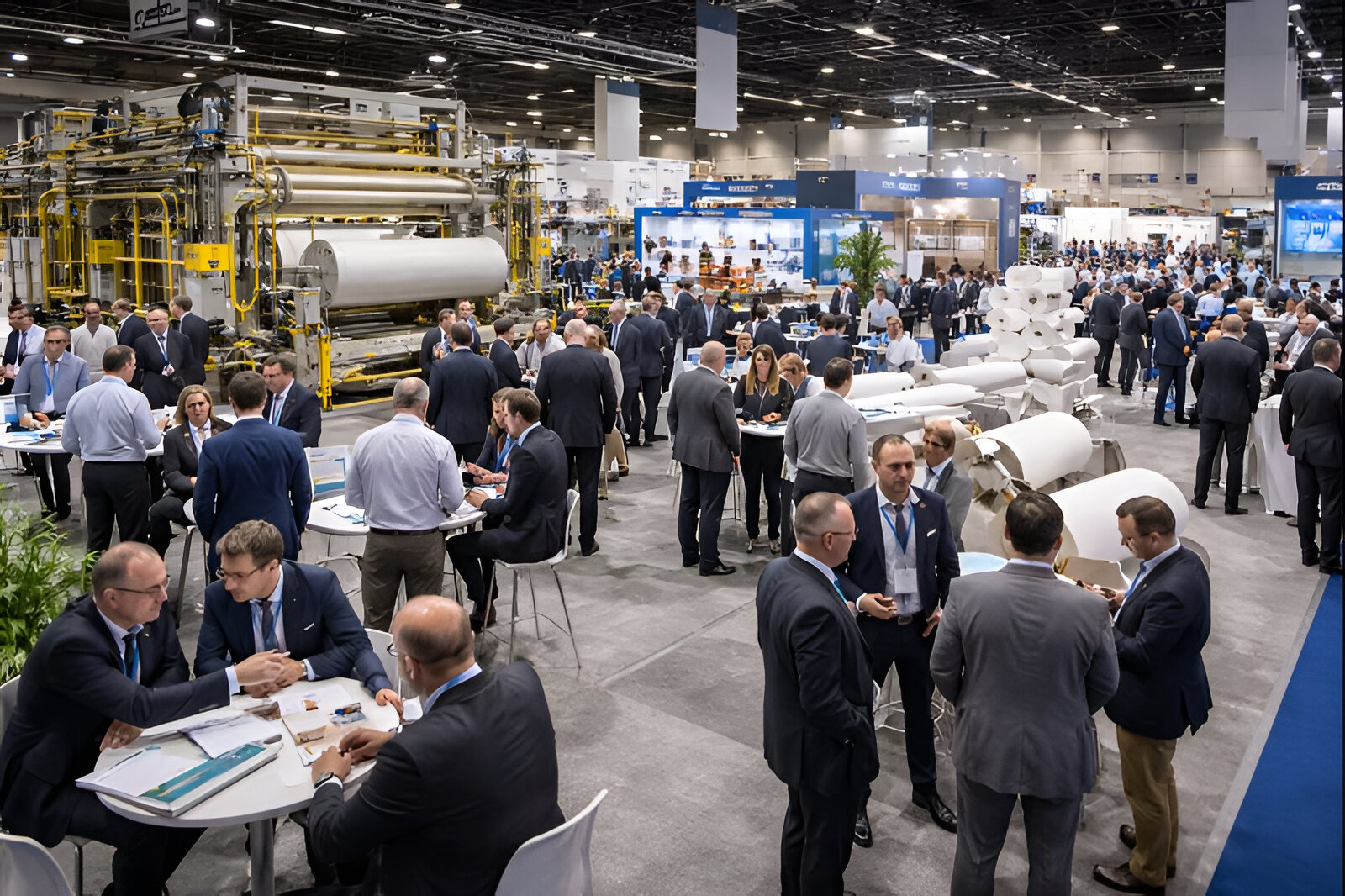 Vista general de una exposición industrial de la industria papelera con stands, maquinaria y empresarios participando de rondas de negocios en una feria internacional