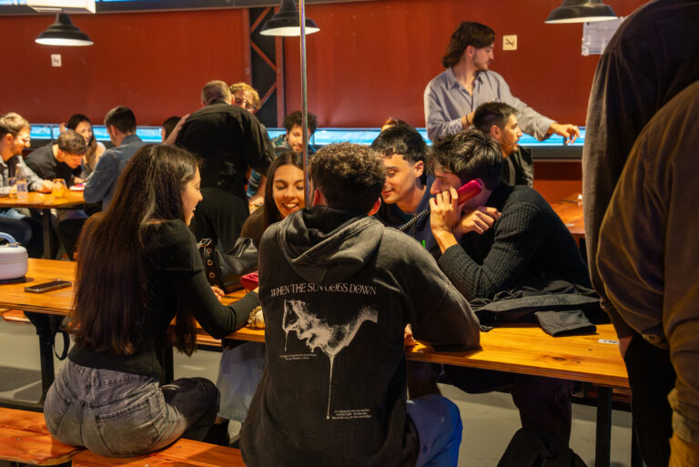 Grupo de jóvenes comparte mesas y conversación en el Fono Bar tras su regreso a la noche de Buenos Aires