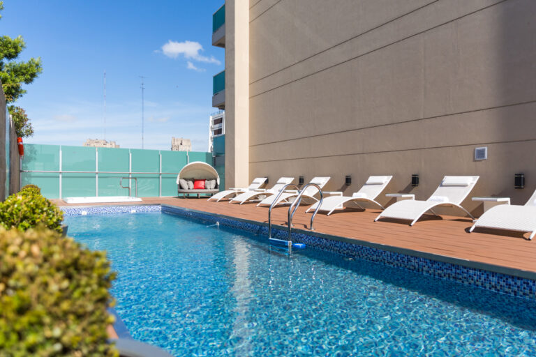 Piscina al aire libre del Palladio Hotel Buenos Aires en Recoleta, con reposeras y ambiente de relax para disfrutar el verano 2026 en la ciudad