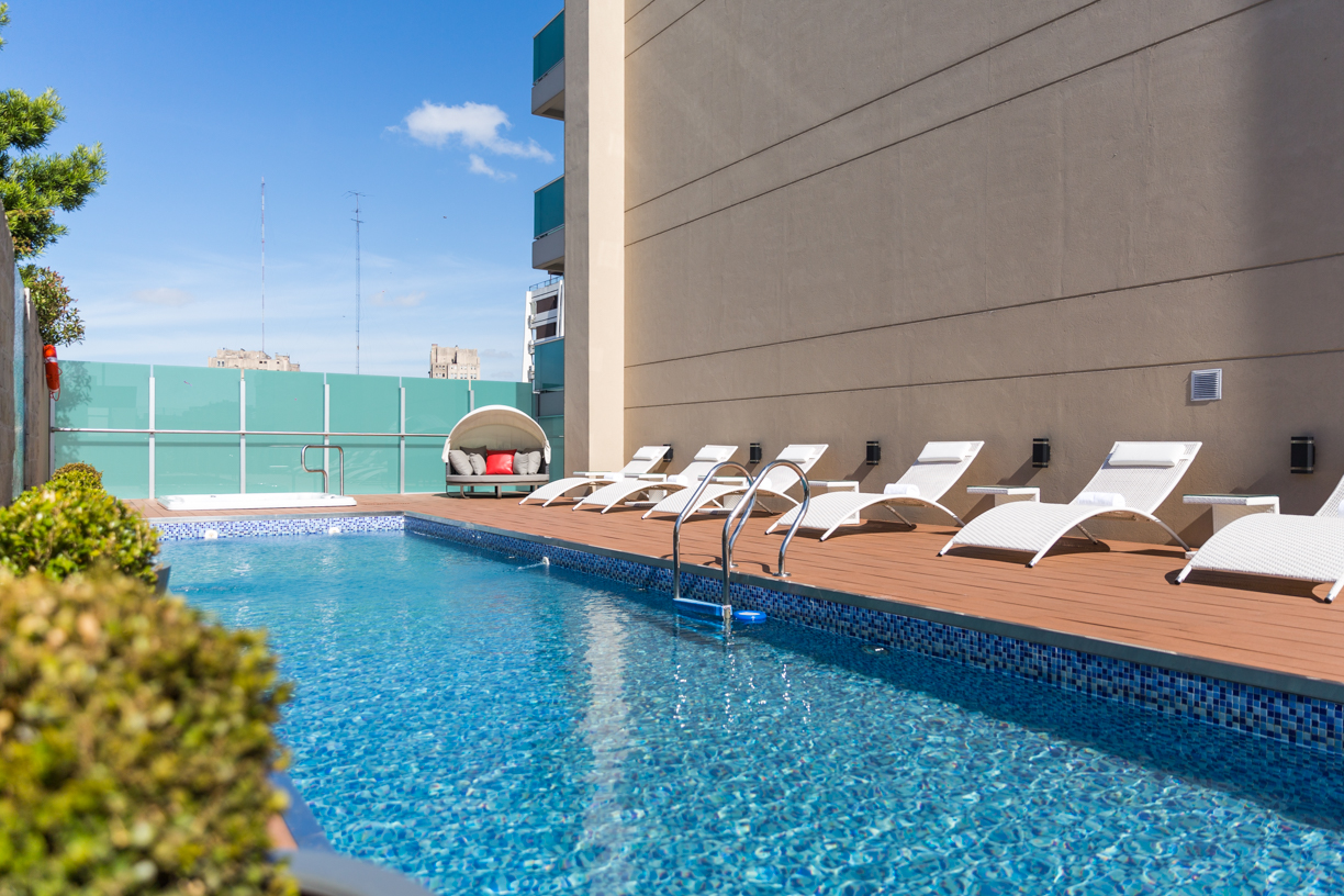 Piscina al aire libre del Palladio Hotel Buenos Aires en Recoleta, con reposeras y ambiente de relax para disfrutar el verano 2026 en la ciudad