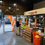 Interior de una tienda Carrefour Express en Argentina con góndolas de productos y clientes realizando compras durante la apertura