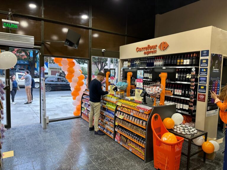 Interior de una tienda Carrefour Express en Argentina con góndolas de productos y clientes realizando compras durante la apertura
