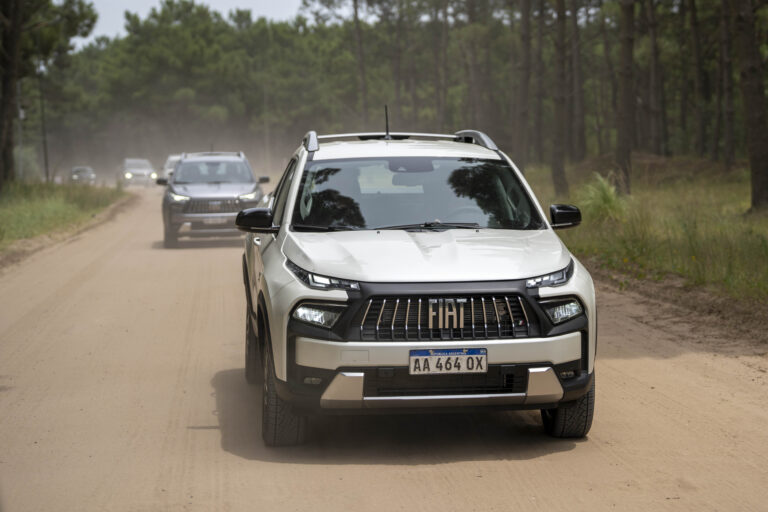 Fiat Toro circulando por camino de tierra rodeado de bosque en Argentina con nuevo diseño frontal y luces LED encendidas