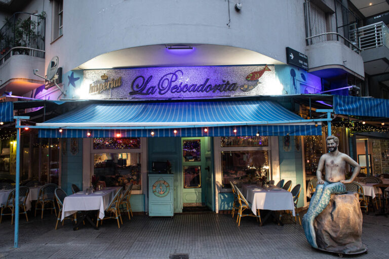 Fachada del restaurante La Pescadorita en Buenos Aires con mesas preparadas en la vereda y ambientación nocturna para una cena especial