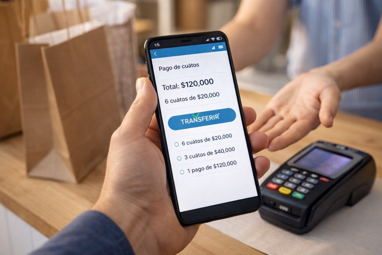 Persona realizando un pago en cuotas desde su celular mediante transferencia inmediata en un comercio con terminal de pago sobre el mostrador