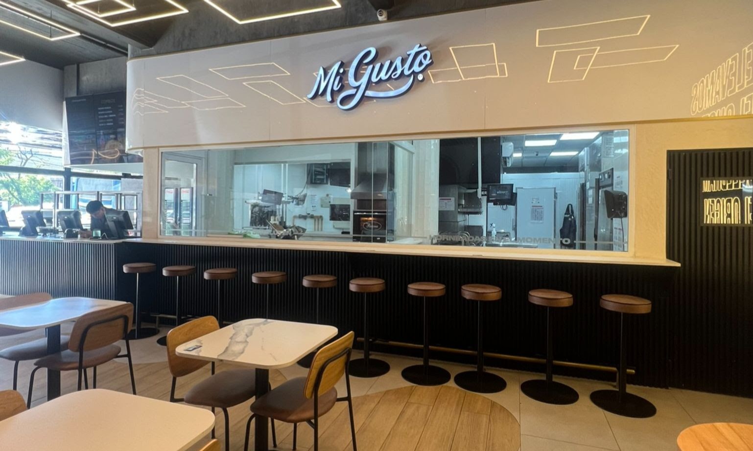 Interior del nuevo local de Mi Gusto en Vicente López con diseño moderno y cocina a la vista