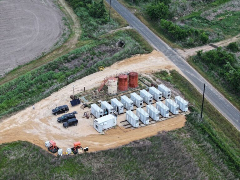 Vista aérea de un yacimiento petrolero con módulos de data centers off grid instalados junto a tanques y equipos energéticos en entorno rural