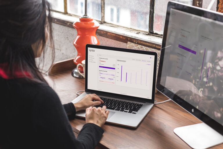 Persona utilizando una computadora portátil con un panel de control financiero digital para gestionar cobros y visualizar datos en tiempo real