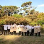 Equipo del restaurante Tres posando al aire libre en un entorno natural durante la temporada en Uruguay