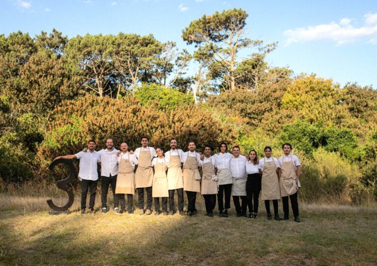 Equipo del restaurante Tres posando al aire libre en un entorno natural durante la temporada en Uruguay