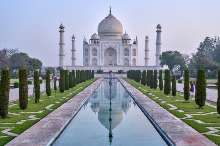 Vista del Taj Mahal en India con jardines y espejo de agua, símbolo de un viaje espiritual y de bienestar