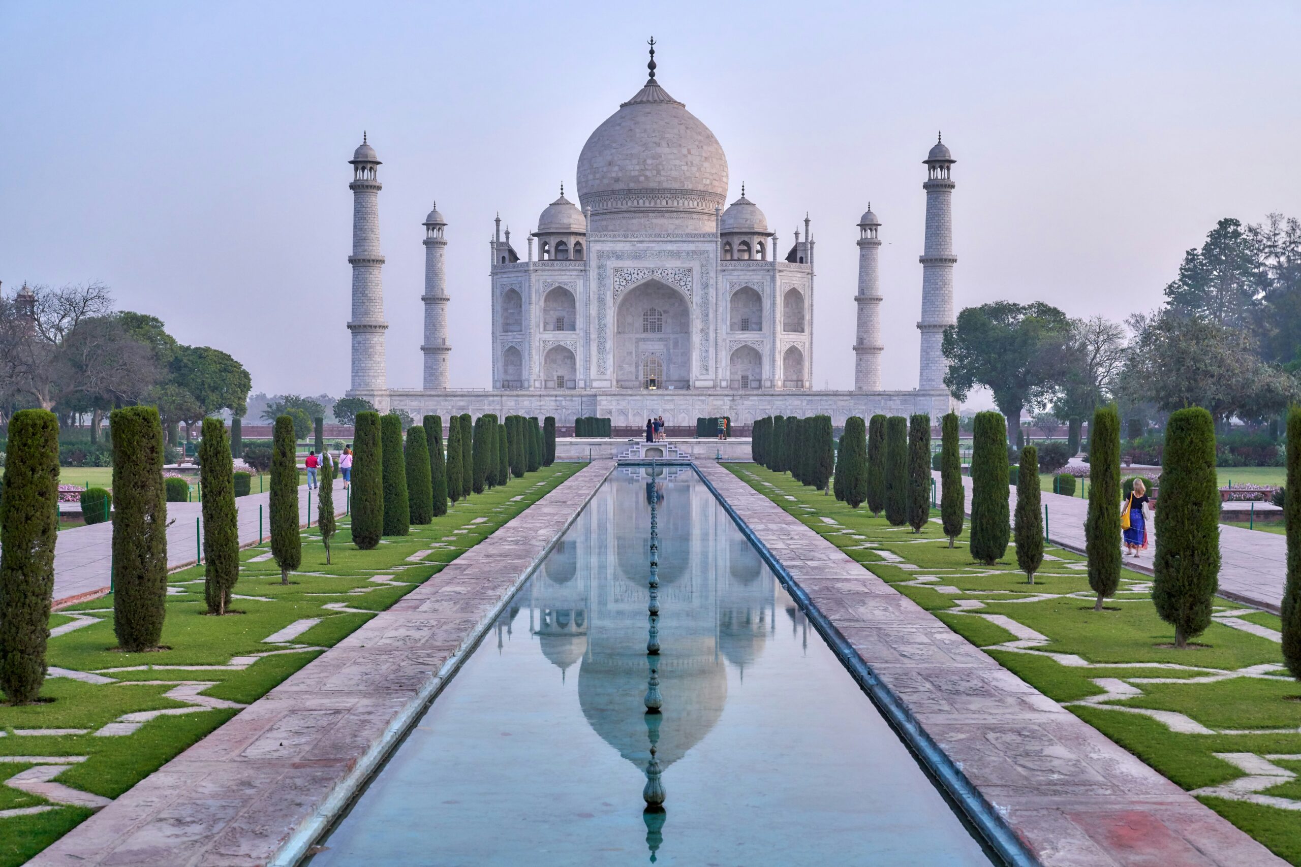 Vista del Taj Mahal en India con jardines y espejo de agua, símbolo de un viaje espiritual y de bienestar