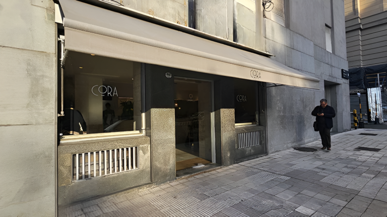 Fachada del café Cora en la planta baja del edificio Kavanagh en Buenos Aires con ingreso vidriado y vereda urbana