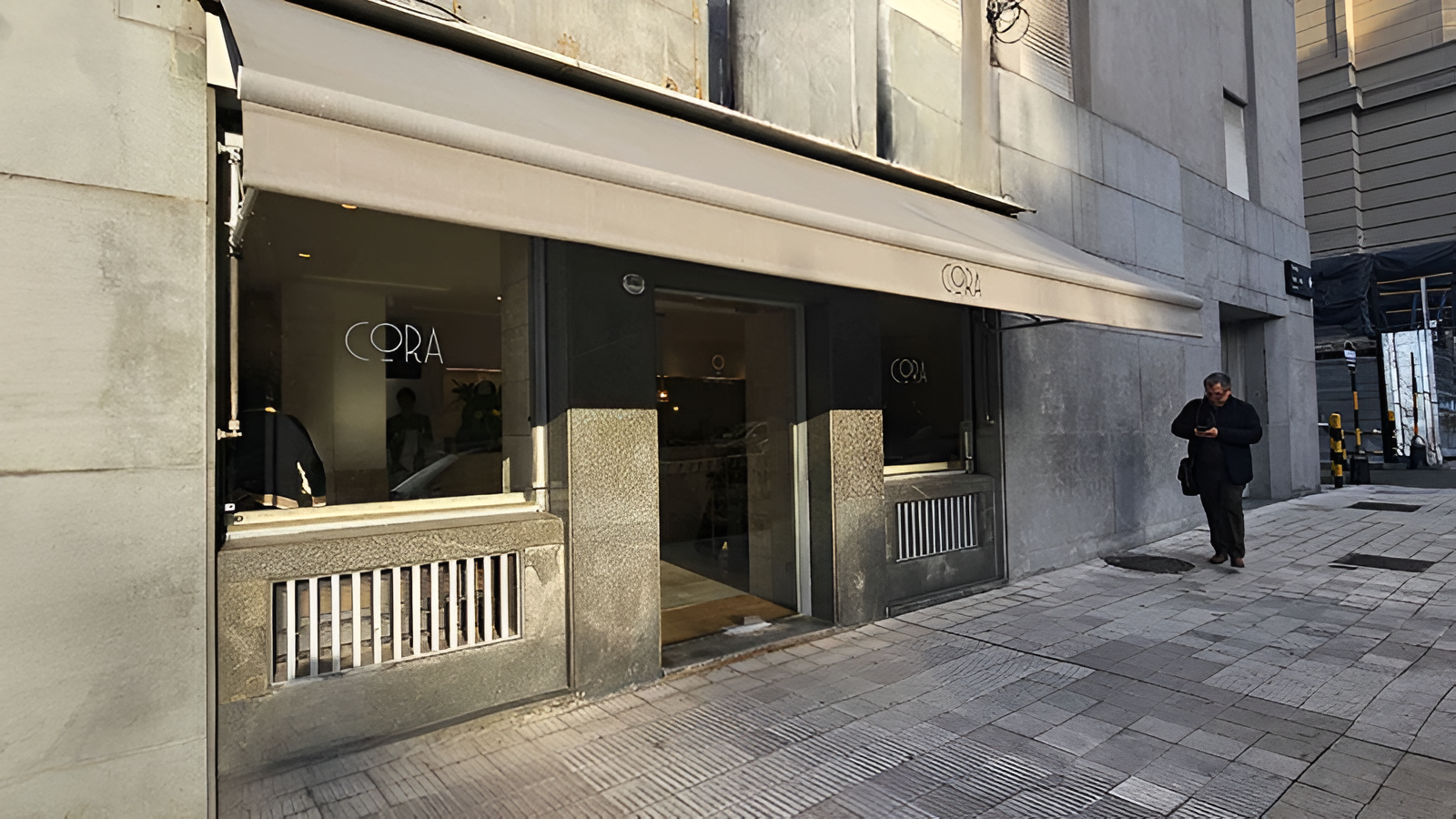 Fachada del café Cora en la planta baja del edificio Kavanagh en Buenos Aires con ingreso vidriado y vereda urbana