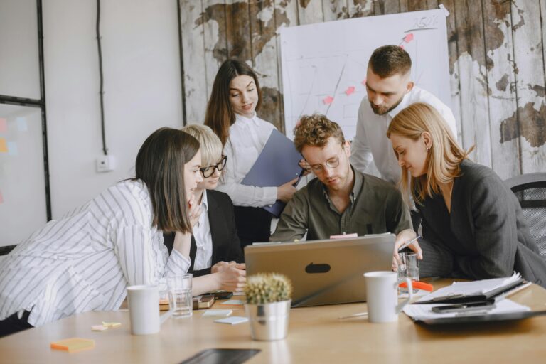 Equipo de trabajo analizando información en una computadora durante una reunión para optimizar la gestión y control de contratistas