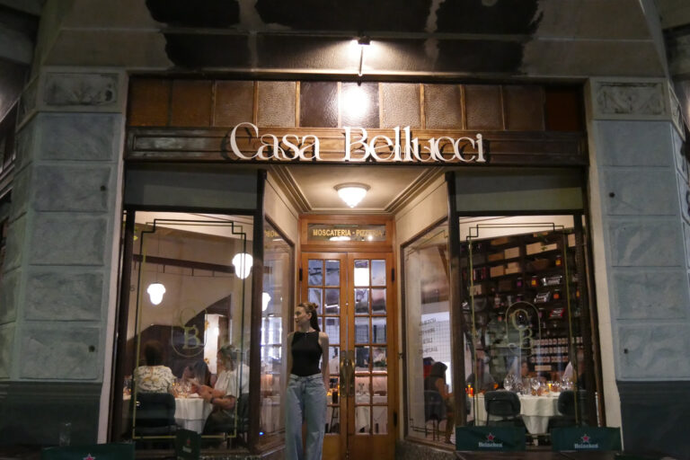Fachada del restaurante Casa Bellucci con comensales en su interior y ambientación cálida en Buenos Aires