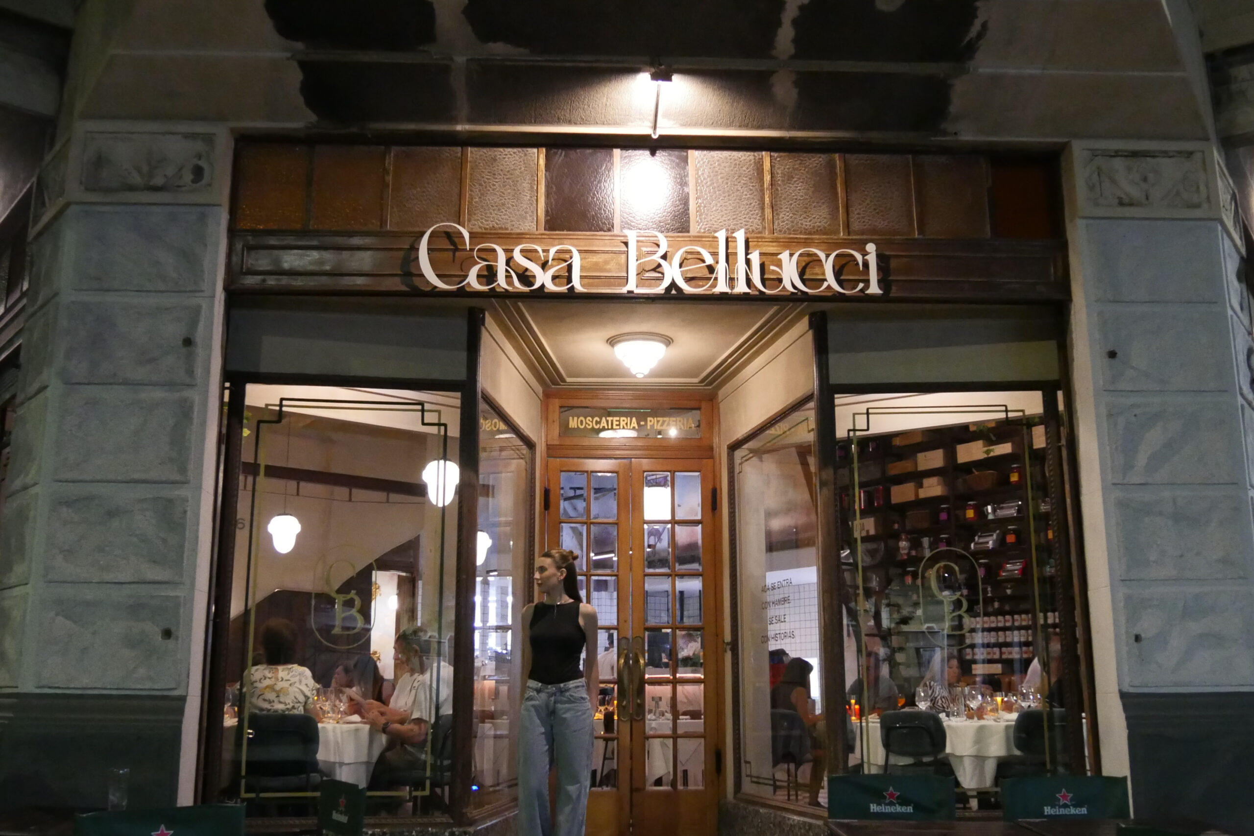 Fachada del restaurante Casa Bellucci con comensales en su interior y ambientación cálida en Buenos Aires