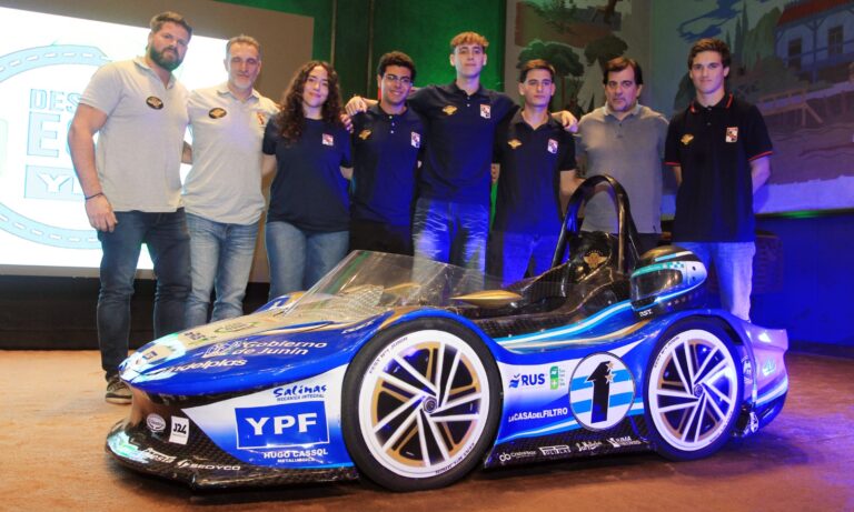 Estudiantes y organizadores junto a un auto eléctrico del Desafío ECO YPF en la presentación oficial en Junín