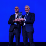 Guillermo Calcagno recibiendo un premio, junto a Francisco De Narváez, durante un evento empresarial del sector retail en Argentina