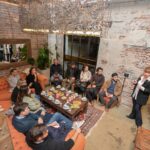 Grupo de personas participando de una degustación de té en un espacio cálido y moderno durante un encuentro organizado por Cachamai